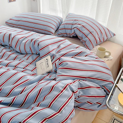 Striped bedding with red and blue lines on a bed in a bedroom setting.