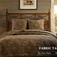 Bedroom with wooden headboard, patterned bedding, and fabric table lamps on nightstands.