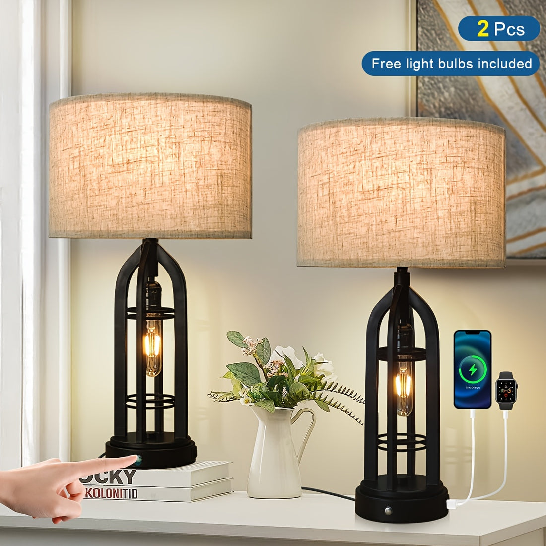 Two table lamps with black metal and beige lampshades on a white surface, with a smartphone and smartwatch charging cable.