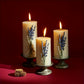 Three lit candles with lavender sprigs on a red background