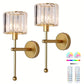 Two gold wall sconces with clear glass shades on a white background, accompanied by a remote control with color options.
