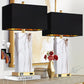 Two decorative lamps with black lampshades on a shelf with books and a vase.