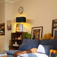 Living room with blue sofa, lamp, and wall clock