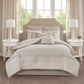 Neatly made bed with decorative pillows in a bedroom setting with two nightstands and lamps.