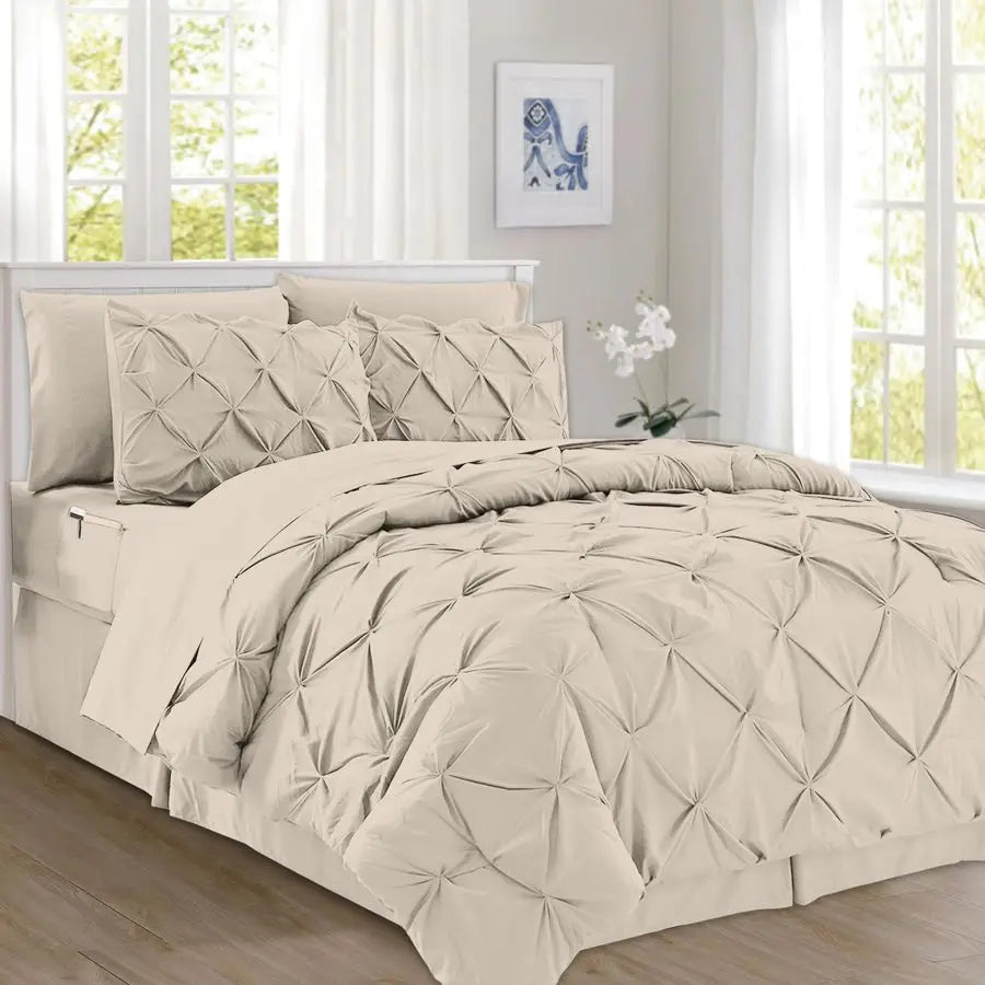 Beige comforter set on a bed in a bright room with large windows.