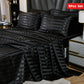 Black striped bedding set on a bed with nightstands in a bedroom setting.