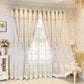 Decorative lace curtains in a stylish room with floral wallpaper and a chandelier.