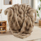 Beige fur throw blanket draped over a chair in a living room setting.