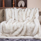 Fluffy white blanket draped over a chair with decorative items in the background