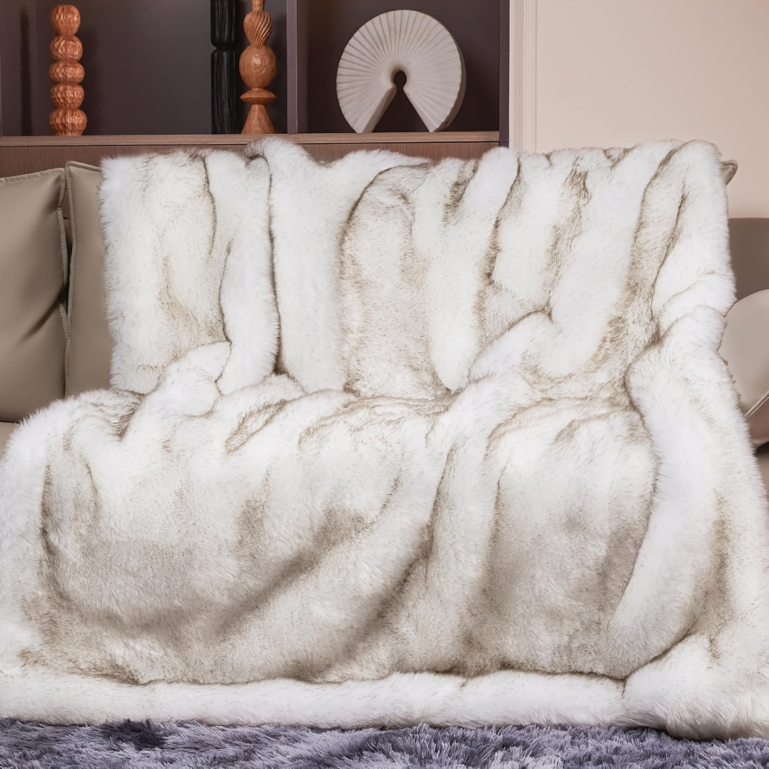Fluffy white blanket draped over a chair with decorative items in the background