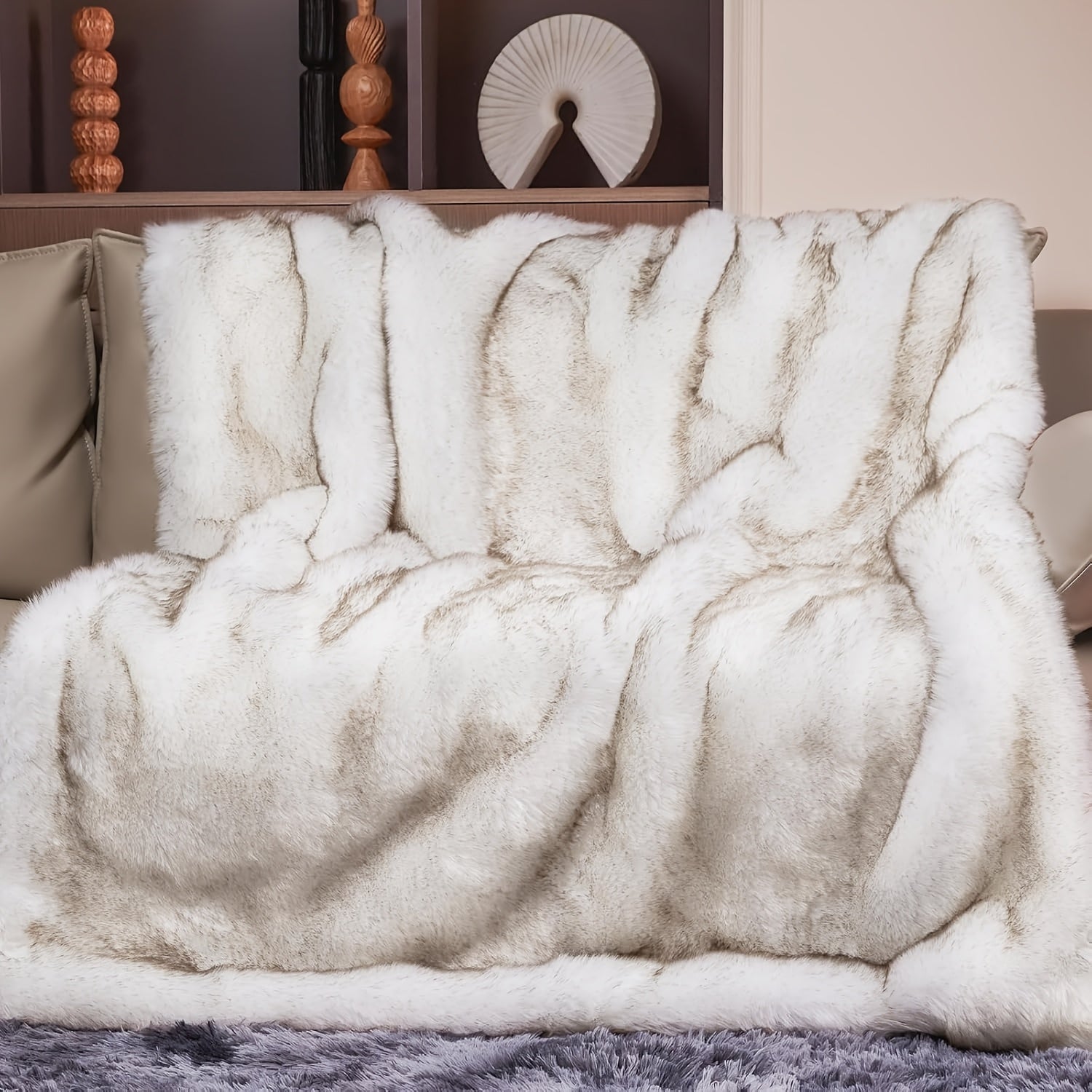 Fluffy white blanket draped over a chair with decorative items in the background