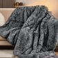Gray faux fur blanket draped over a couch in a cozy living room setting.