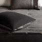 Gray cushion on a textured surface with a focus on texture and color.