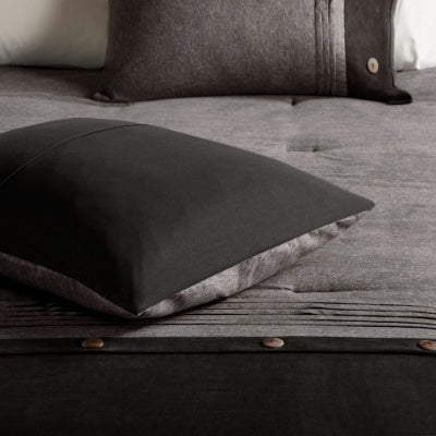 Gray cushion on a textured surface with a focus on texture and color.