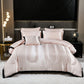Pink satin comforter set on a bed in a stylish bedroom with side tables and decor.