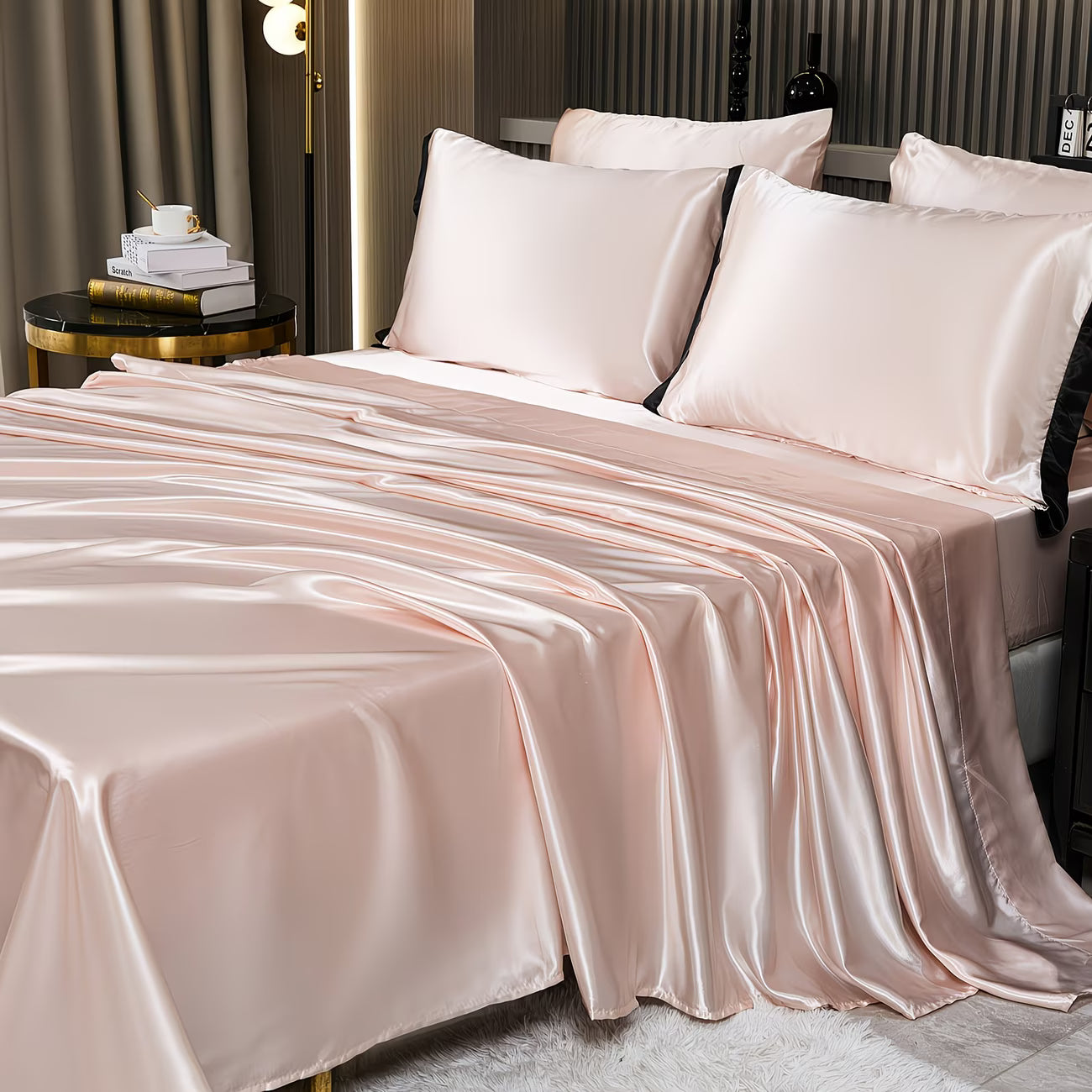 Pink satin bedding set on a bed in a bedroom setting.