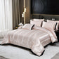 Neatly made bed with satin comforter and pillows in a modern bedroom setting.