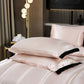 Pink satin pillows on a bed in a stylish bedroom setting.