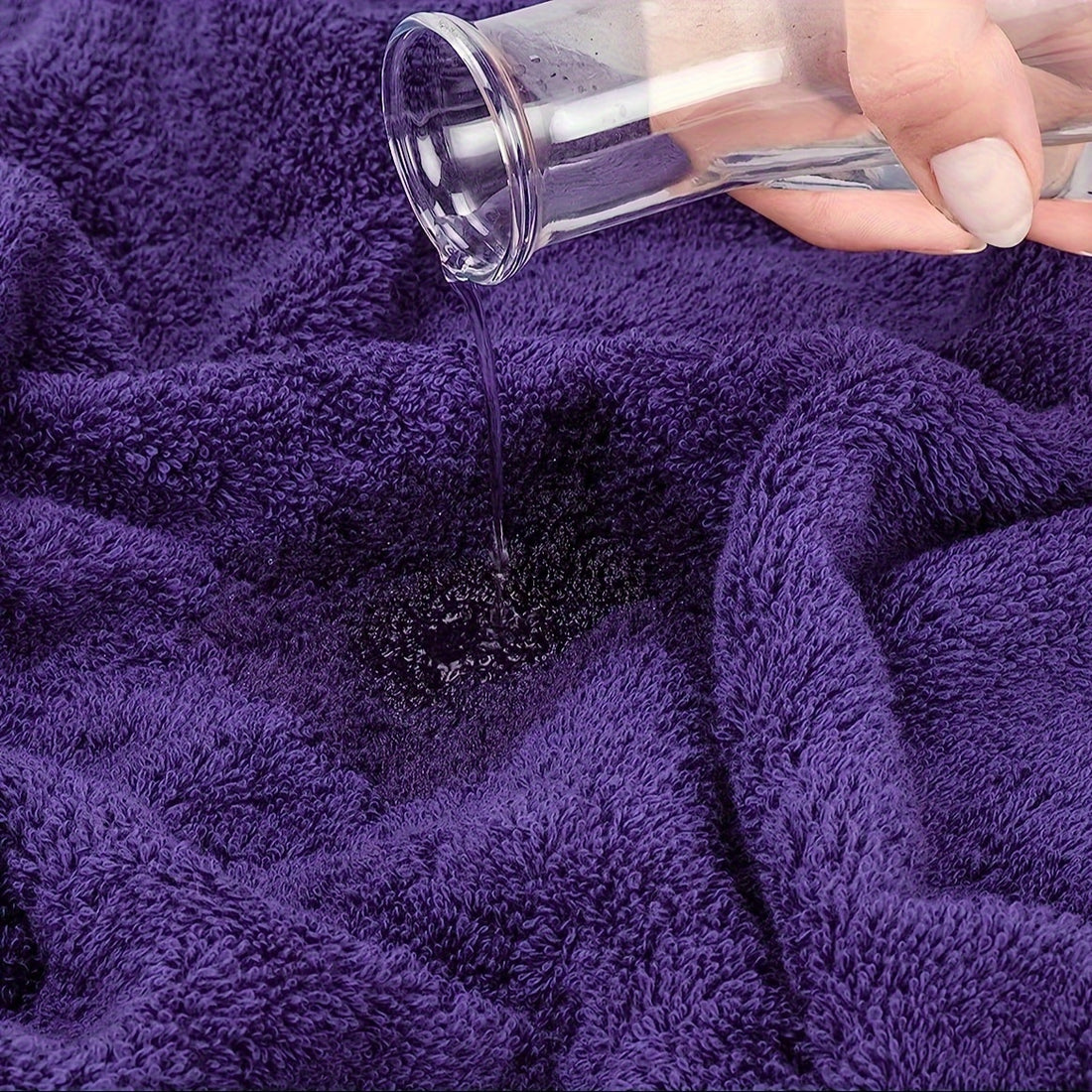 Hand pouring a dark powder onto a purple towel