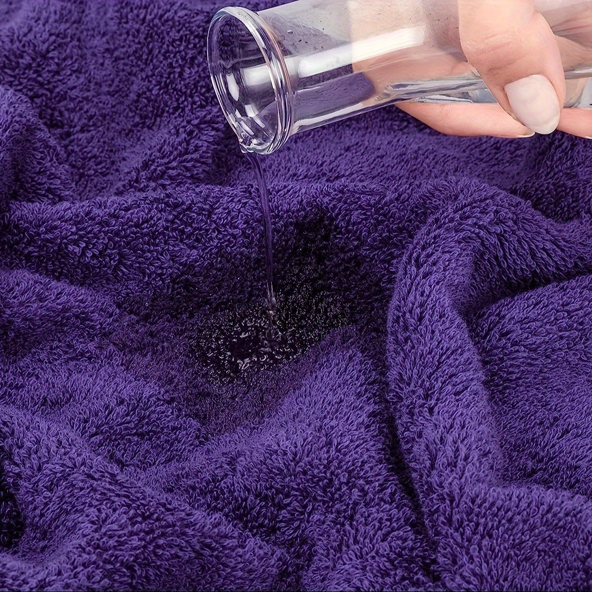 Hand pouring a dark powder onto a purple towel