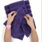 Purple towels being held by hands on a white background