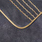 Dark gray bath mat with beige border and stitching