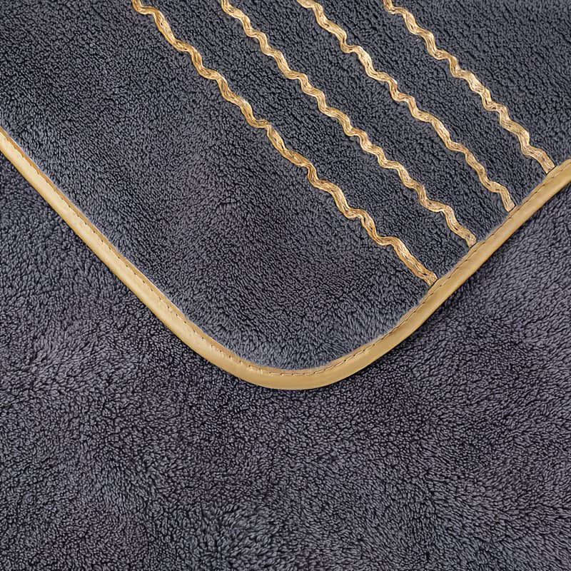 Dark gray bath mat with beige border and stitching