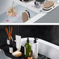 Bathroom shelf with various toiletries and decorative items on a white and black tiled wall background.