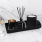 Decorative set with candle, diffuser, and other items on a marble surface