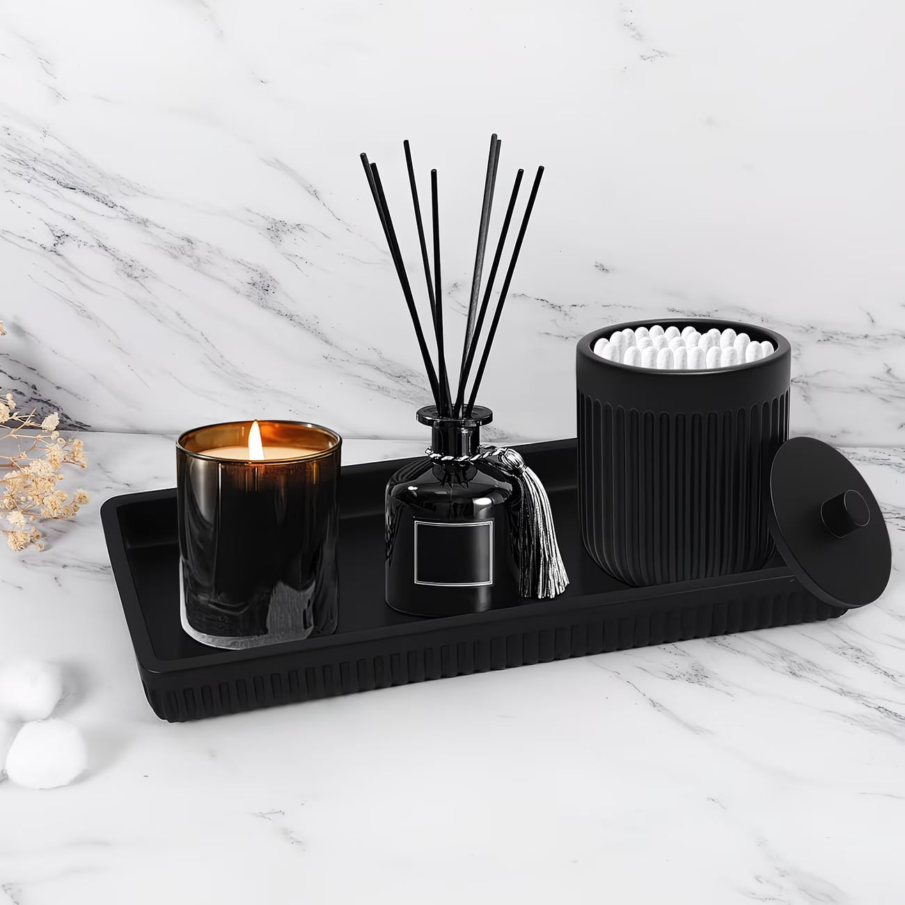 Decorative set with candle, diffuser, and other items on a marble surface