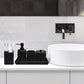 Bathroom sink area with black toiletry set and white sink.