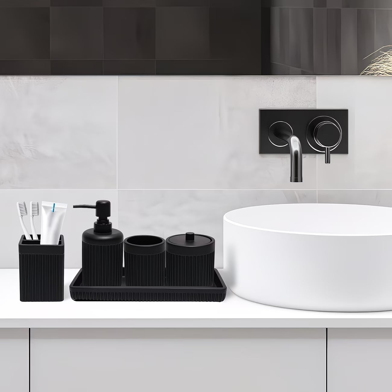 Bathroom sink area with black toiletry set and white sink.