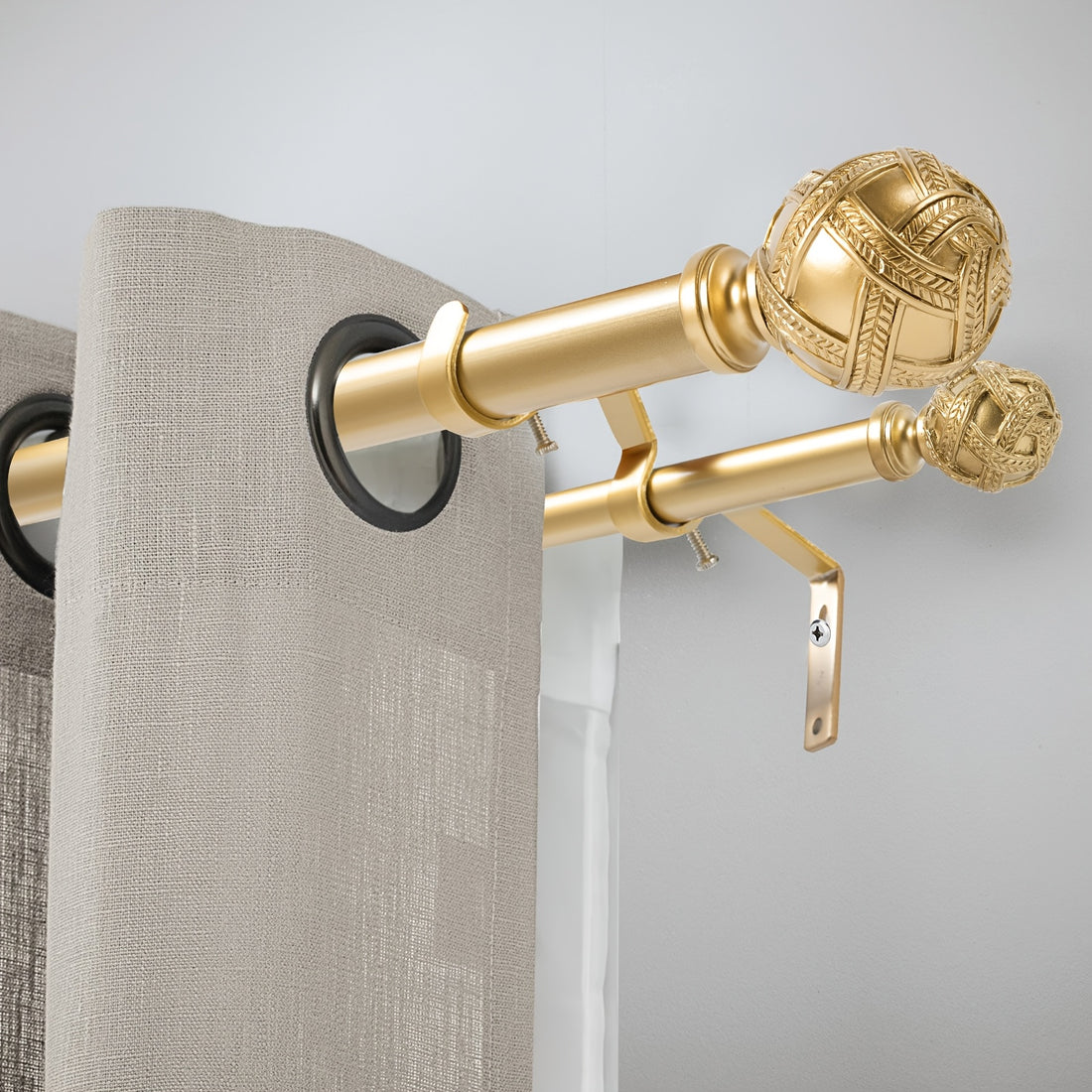 Gold decorative curtain rod with beige curtains on a light gray background