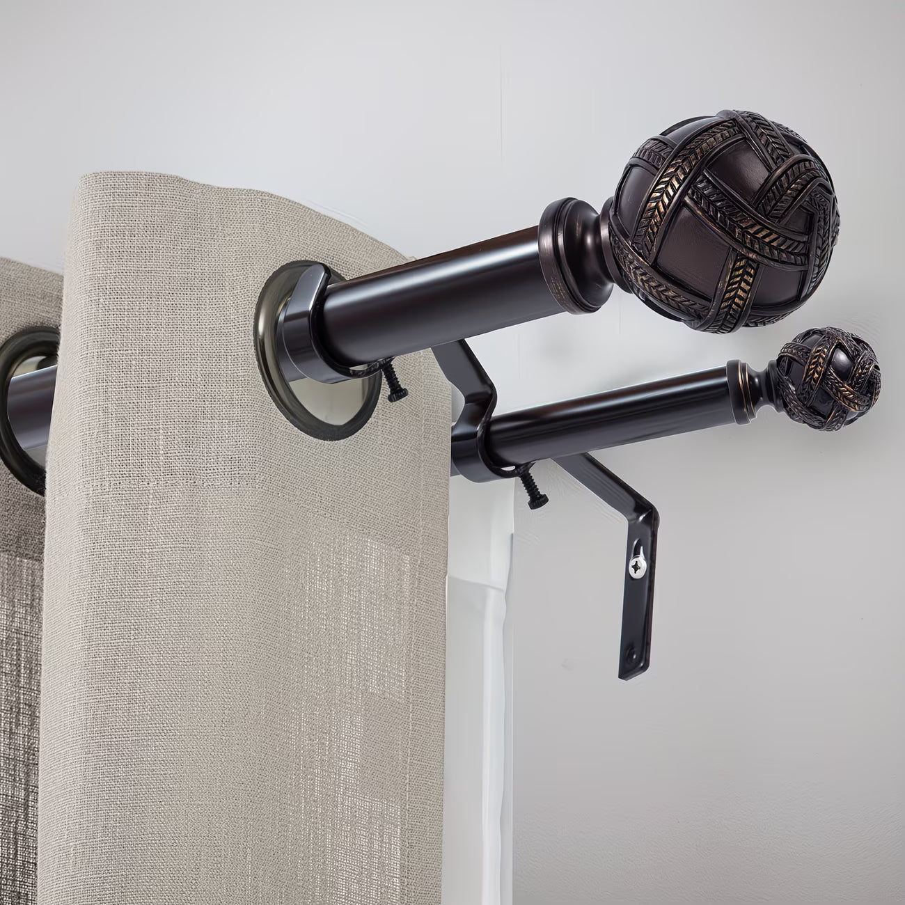 Curtain rod with decorative finials and beige curtains against a white wall