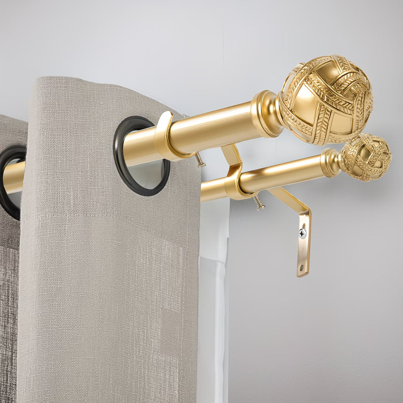 Gold decorative curtain rod with beige curtains on a light gray background