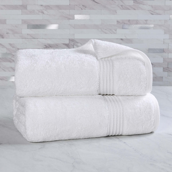 Two white towels stacked on a marble surface with a marble wall background