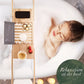 Woman relaxing in a bathtub with a wooden bath caddy and candles.