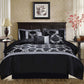Black and gray patterned bedding set on a bed in a bedroom with decorative elements.
