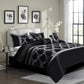 Black and white floral comforter set on a bed in a bedroom with side table and decor.