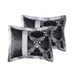 Two black satin pillows with silver floral patterns on a white background