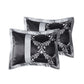 Two black satin pillows with silver floral patterns on a white background