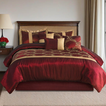 Red and gold patterned comforter set on a bed in a bedroom setting.