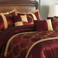 Maroon and gold bedding set on a bed with matching pillows.