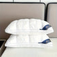 Two white pillows with a brand logo on a bed