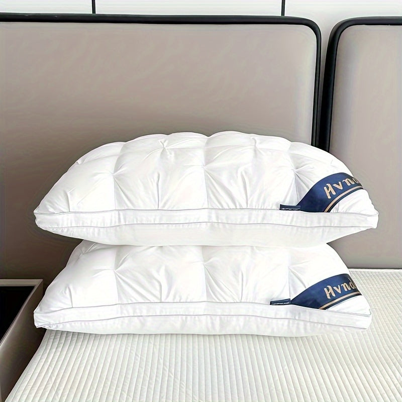 Two white pillows with a brand logo on a bed