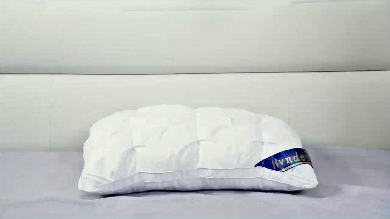 White pillow with a brand logo on a gray background