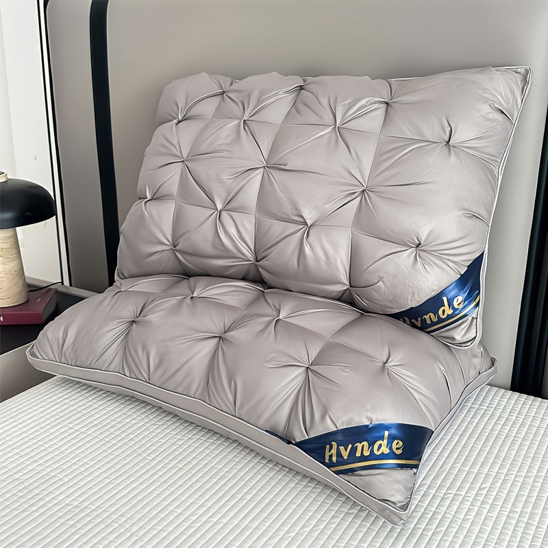 Gray quilted pillow with 'Hynde' branding on a bed