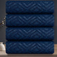 Stack of four blue towels with a geometric pattern on a dark background