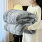 Person holding a large gray and white blanket in a home setting