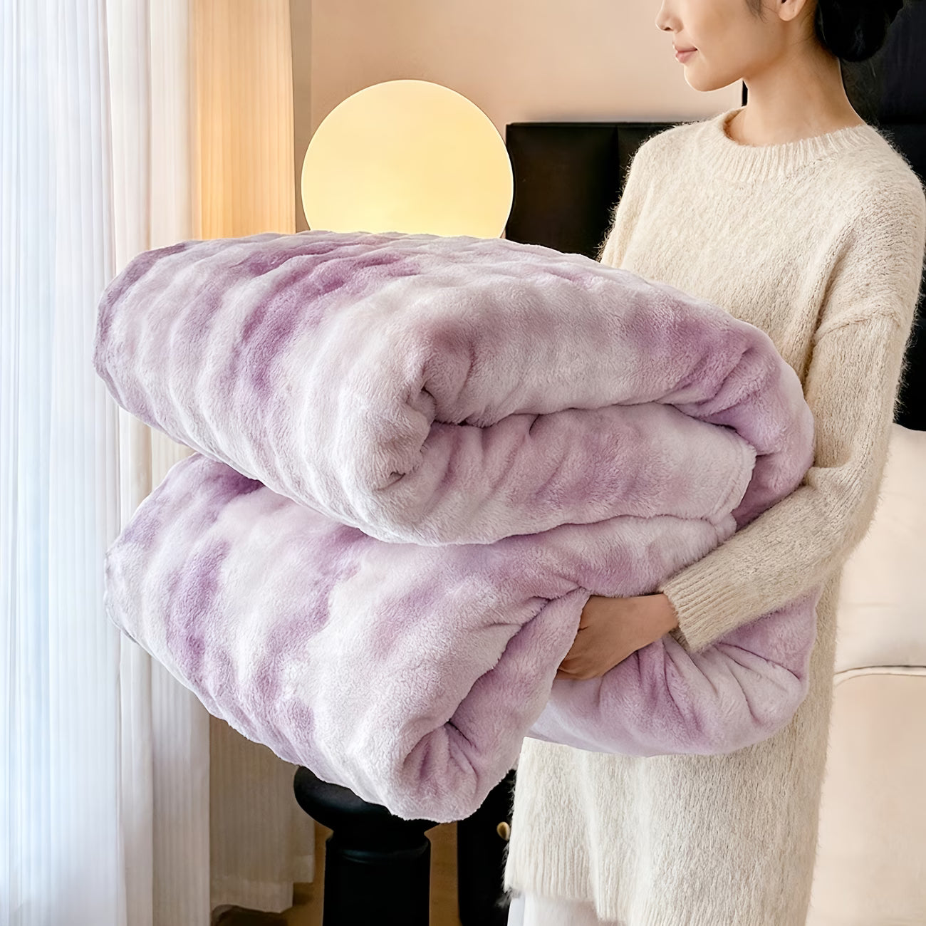 Person holding a large pink blanket in a cozy indoor setting